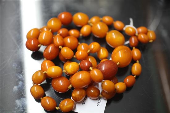 A single strand graduated oval amber bead necklace, 43in.